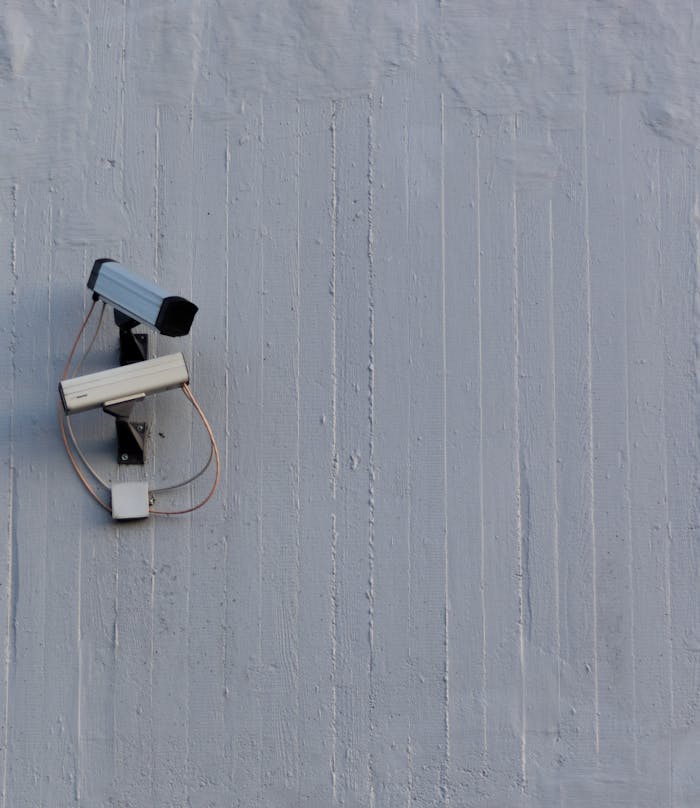 Crafting Captivating Headlines: Your awesome post title goes here Two surveillance cameras mounted on a wall for security and safety monitoring.