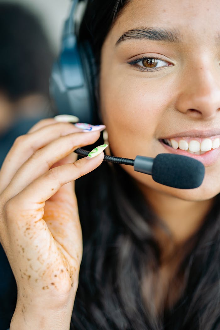 Close-up of a cheerful woman with headphones, engaged in a customer service role.